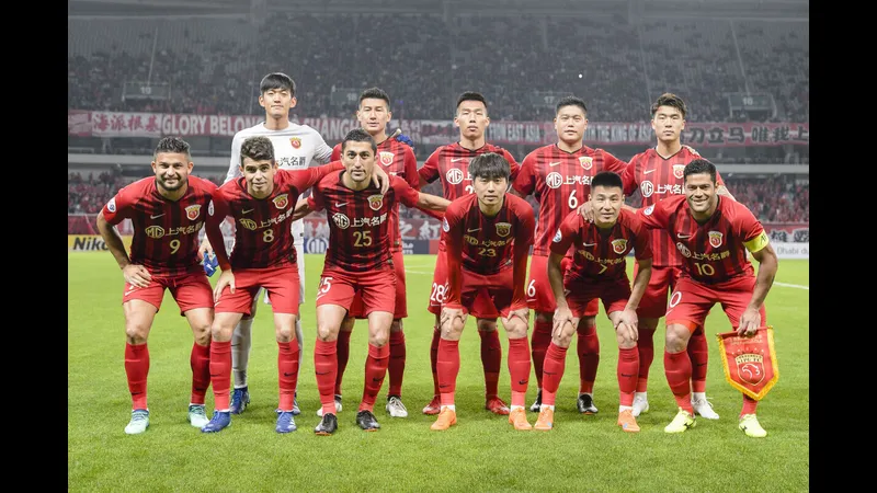 Hậu vệ Dalian Yingbo cản phá cú sút của tiền đạo Shanghai Port Hậu vệ Dalian Yingbo cản phá cú sút của tiền đạo Shanghai Port